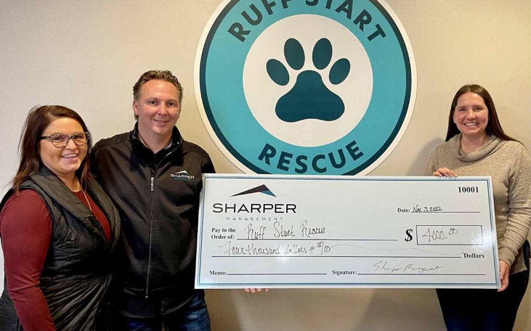 Sharper Management giving large check to Ruff Start Rescue employee